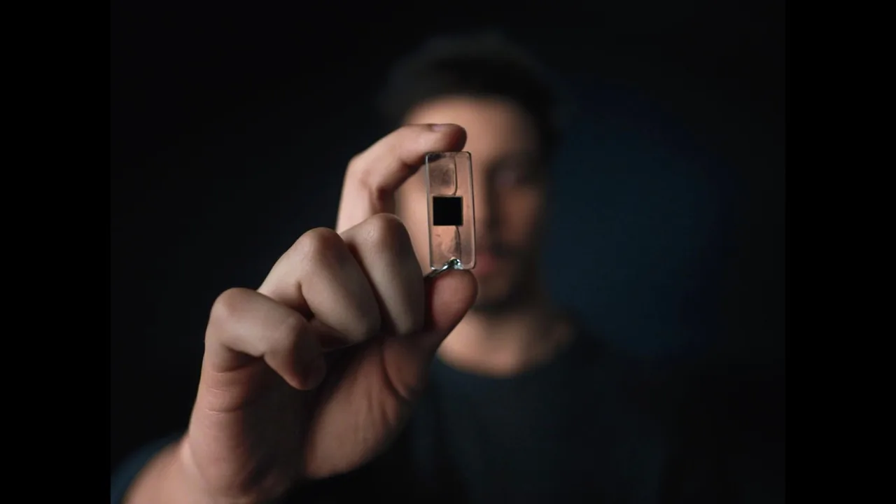 A hand holding a small Apollo Atomics reactor component